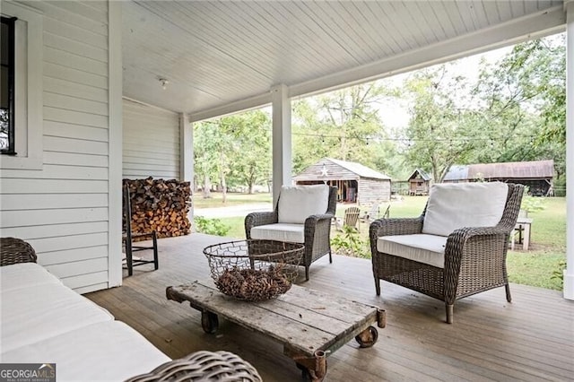 wooden terrace featuring an outdoor living space and an outdoor structure