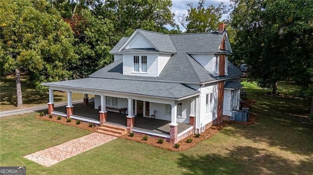 view of front of house featuring cooling unit, covered porch, and a front lawn