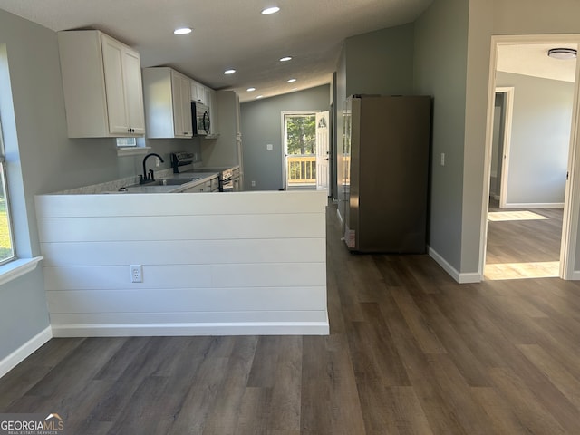 kitchen with white cabinets, sink, appliances with stainless steel finishes, vaulted ceiling, and dark hardwood / wood-style flooring