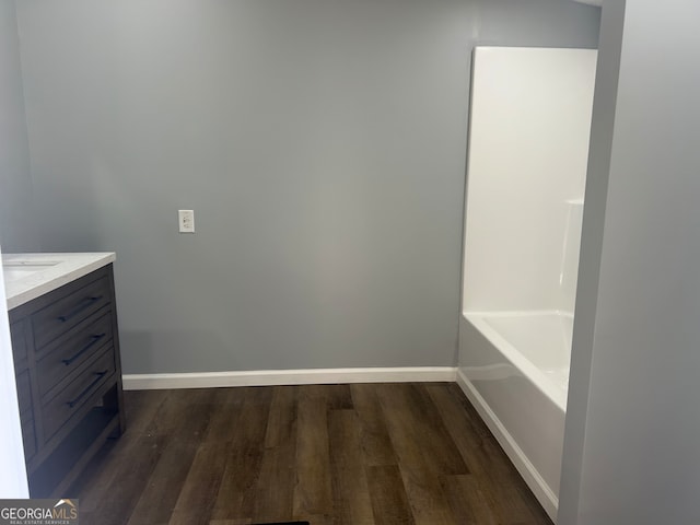 bathroom featuring wood-type flooring, vanity, and a bathing tub