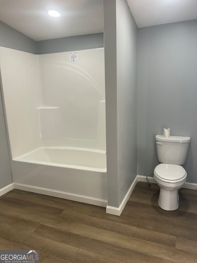 bathroom featuring a textured ceiling, toilet, hardwood / wood-style floors, and shower / bath combination