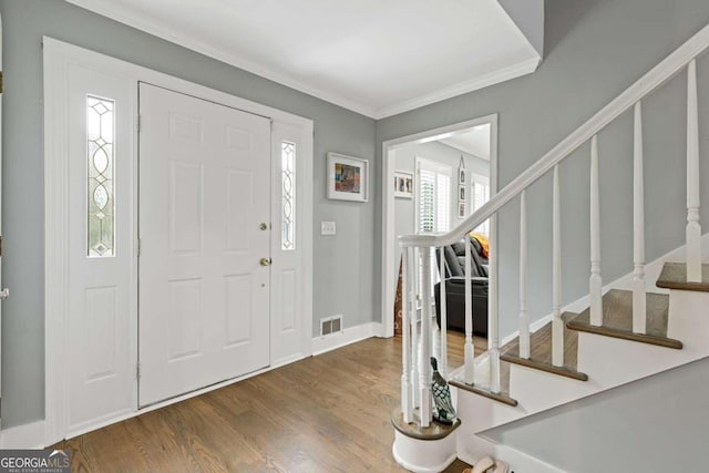 foyer entrance featuring hardwood / wood-style flooring and ornamental molding