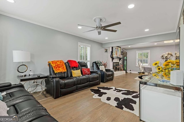 living room with light hardwood / wood-style flooring, ceiling fan, and ornamental molding