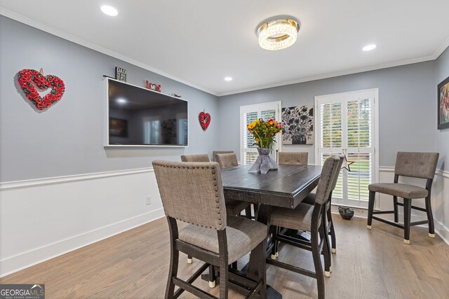 dining room with light hardwood / wood-style flooring and crown molding