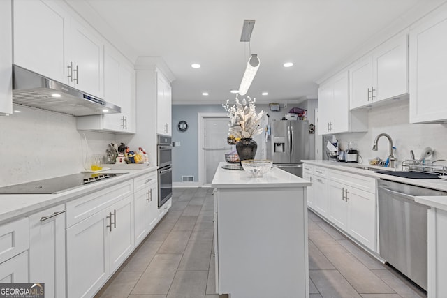 kitchen with appliances with stainless steel finishes, white cabinetry, and a kitchen island