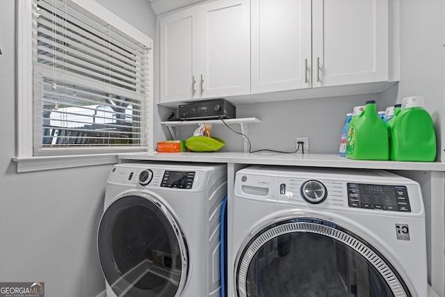 laundry area featuring washing machine and dryer and cabinets