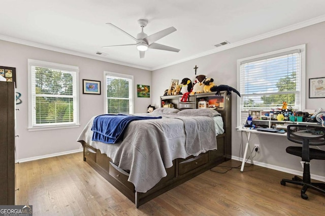 bedroom with multiple windows, ceiling fan, crown molding, and wood-type flooring