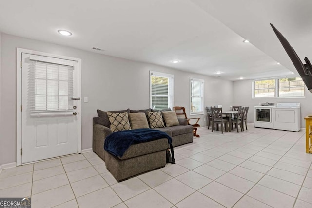 living room with washer and clothes dryer and light tile patterned floors