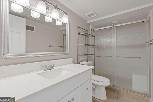 bathroom featuring tile patterned flooring, vanity, an enclosed shower, and toilet