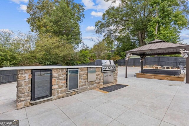 view of patio / terrace featuring a gazebo, area for grilling, and exterior kitchen