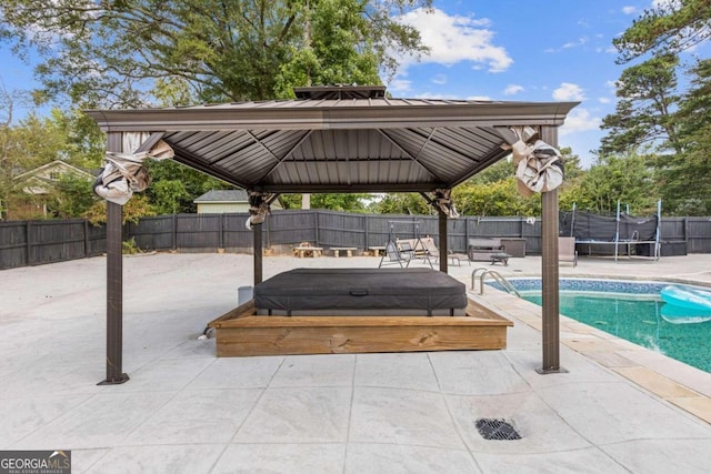 view of patio with a gazebo, a trampoline, and a fenced in pool