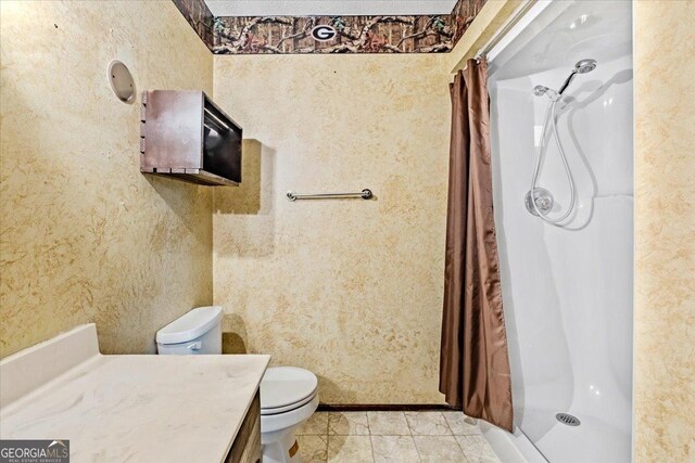 bathroom with a shower with shower curtain, vanity, toilet, and tile patterned flooring