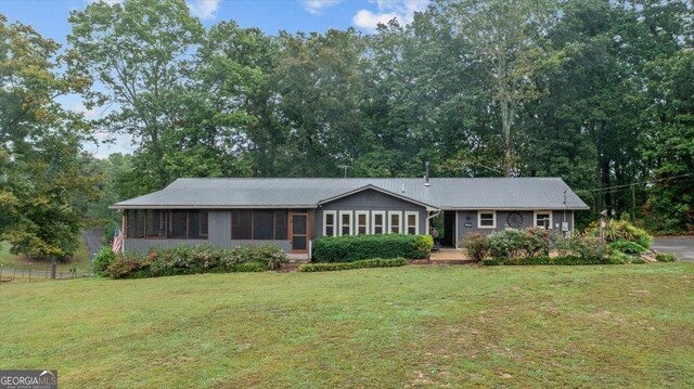 ranch-style house with a front yard and a sunroom