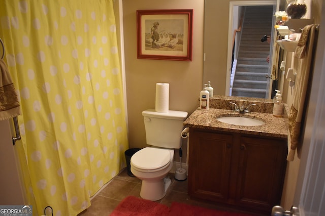 bathroom featuring tile patterned flooring, curtained shower, vanity, and toilet