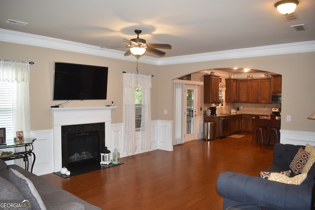 living room featuring crown molding, dark hardwood / wood-style flooring, and a wealth of natural light