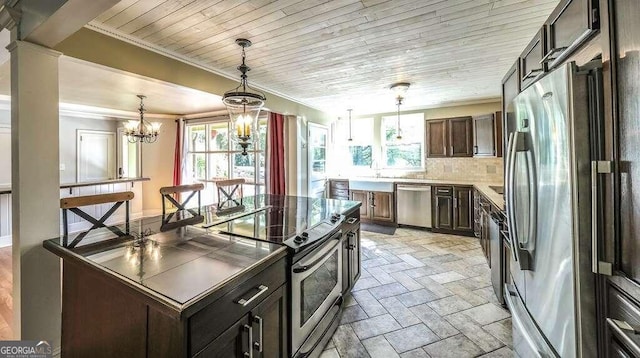 kitchen with dark brown cabinets, a center island, a notable chandelier, stainless steel appliances, and backsplash