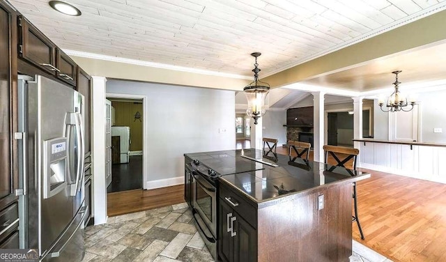 kitchen with dark brown cabinets, decorative light fixtures, stainless steel fridge with ice dispenser, decorative columns, and a fireplace