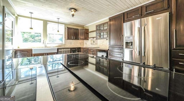 kitchen featuring dark brown cabinets, sink, hanging light fixtures, decorative backsplash, and stainless steel appliances