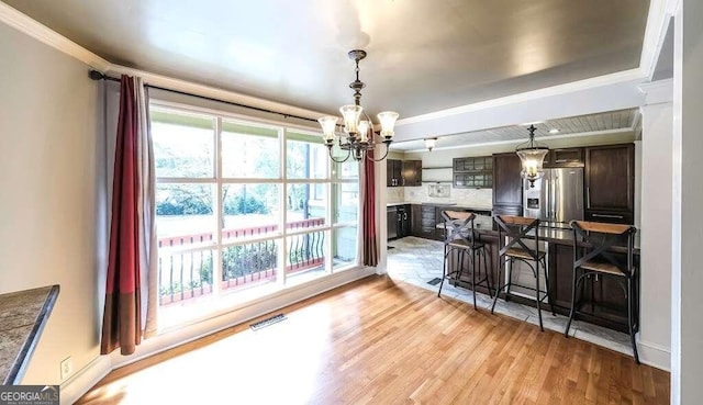 interior space with a notable chandelier, light hardwood / wood-style floors, and crown molding