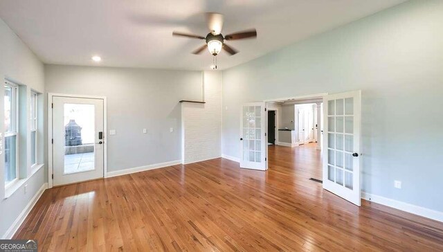 spare room featuring wood-type flooring, ceiling fan, and french doors