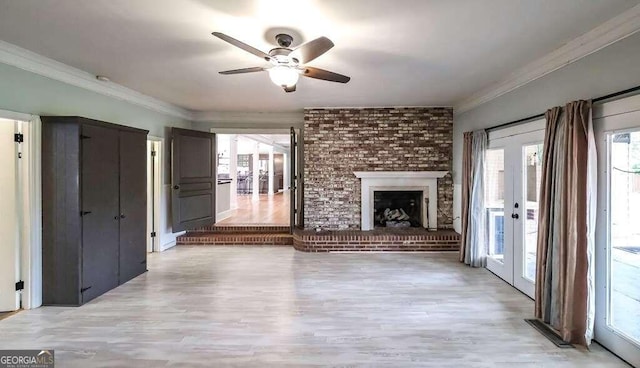 unfurnished living room featuring a fireplace, light hardwood / wood-style flooring, ornamental molding, ceiling fan, and french doors