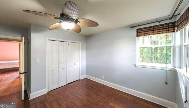 unfurnished bedroom with ceiling fan, a closet, and dark hardwood / wood-style flooring