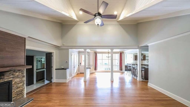 unfurnished living room with light wood-type flooring, wooden ceiling, ceiling fan, and ornate columns