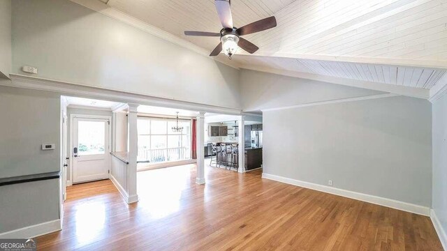 unfurnished living room with light hardwood / wood-style floors, wood ceiling, beamed ceiling, ceiling fan, and decorative columns