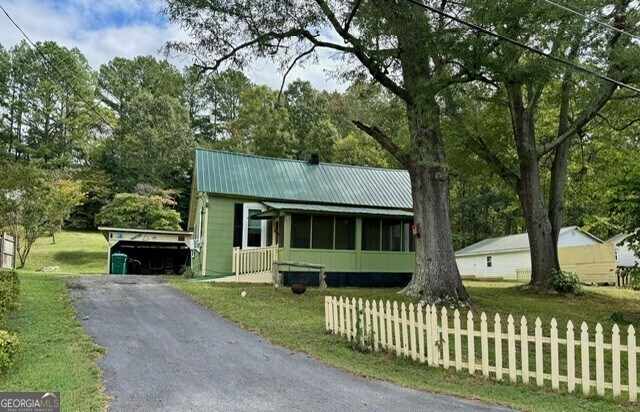 view of front of property with a front lawn and a carport