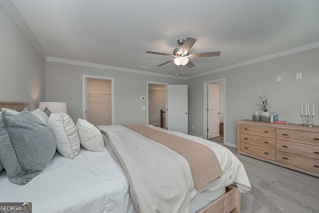 bedroom featuring a closet, light carpet, crown molding, a spacious closet, and ceiling fan