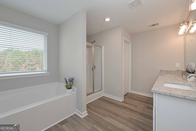 bathroom featuring vanity, plus walk in shower, and hardwood / wood-style flooring