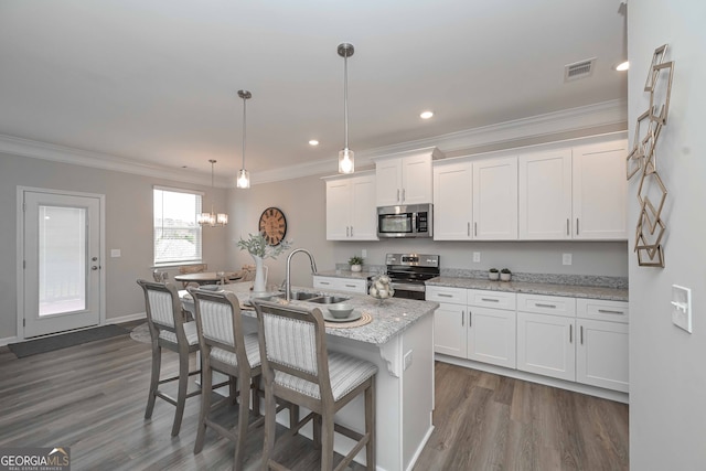 kitchen featuring sink, an island with sink, white cabinets, hanging light fixtures, and appliances with stainless steel finishes