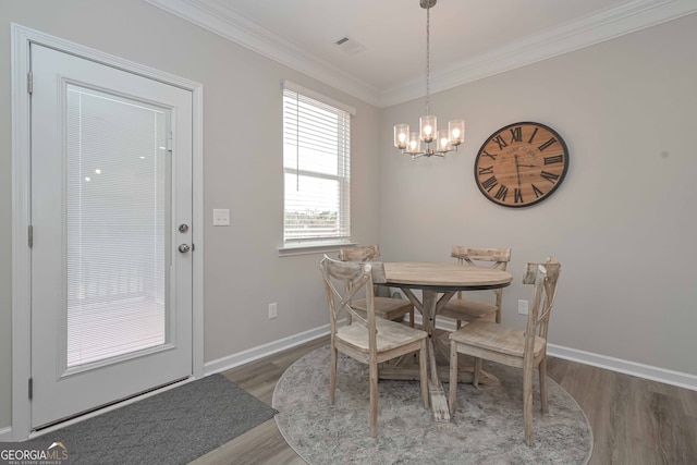 dining area with crown molding, dark hardwood / wood-style floors, and a notable chandelier