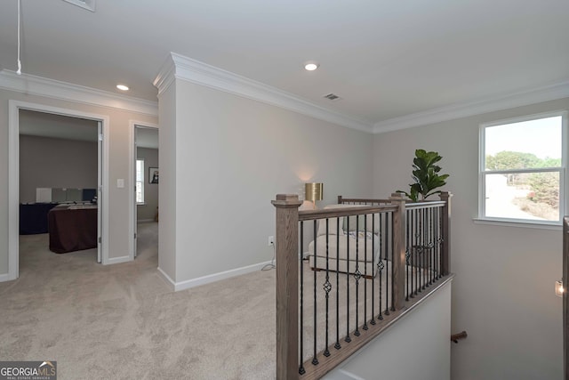 hallway with ornamental molding and light colored carpet