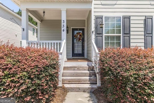 view of exterior entry featuring covered porch