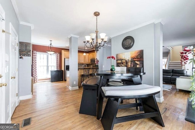 dining space featuring ornamental molding, light hardwood / wood-style flooring, and a notable chandelier