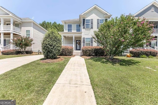 view of front of house with a balcony, a porch, and a front lawn