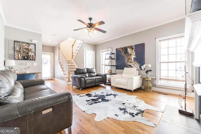 living room featuring ornamental molding, wood-type flooring, and ceiling fan