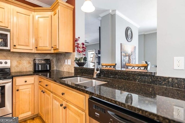 kitchen featuring kitchen peninsula, sink, stainless steel appliances, dark stone counters, and crown molding