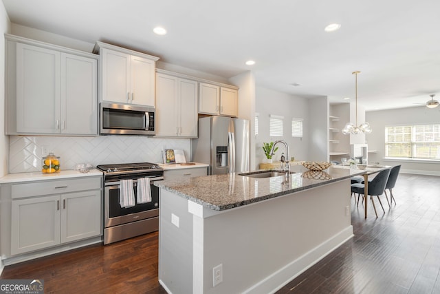 kitchen featuring appliances with stainless steel finishes, dark hardwood / wood-style floors, a kitchen island with sink, and sink