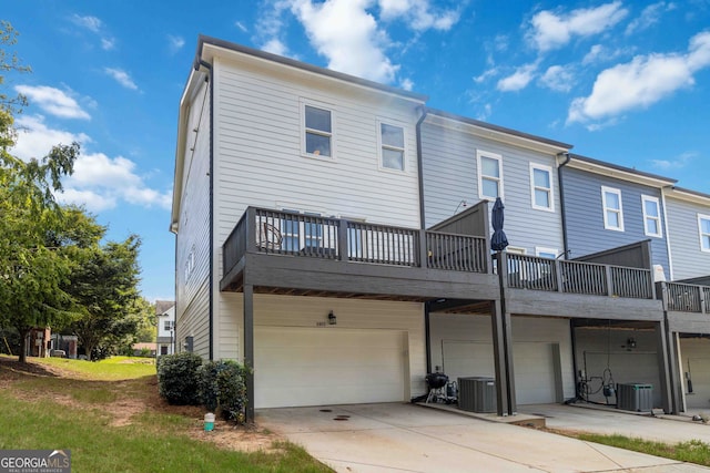 back of property featuring a wooden deck, a garage, and central AC