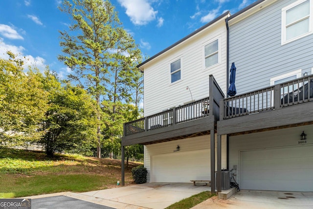 view of side of property featuring a garage and central AC unit