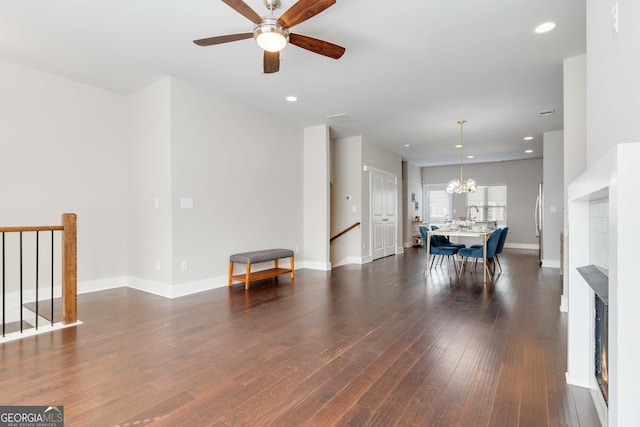 interior space with ceiling fan with notable chandelier and dark wood-type flooring