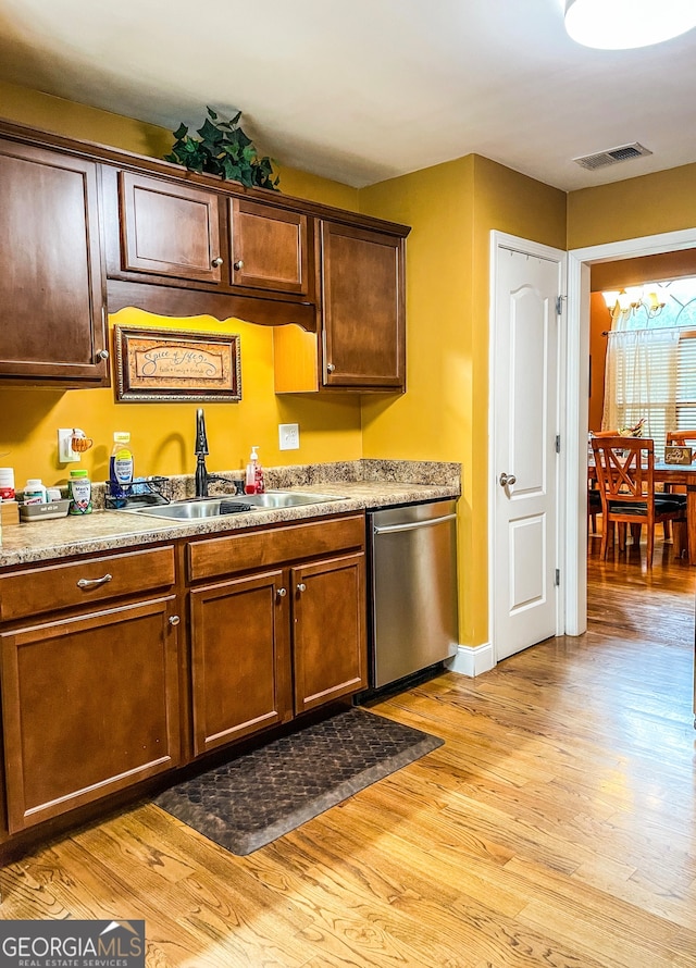 kitchen featuring light hardwood / wood-style floors, stainless steel dishwasher, an inviting chandelier, and sink