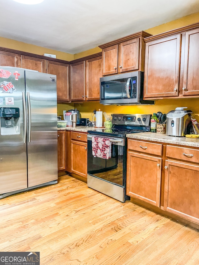 kitchen featuring appliances with stainless steel finishes and light hardwood / wood-style floors