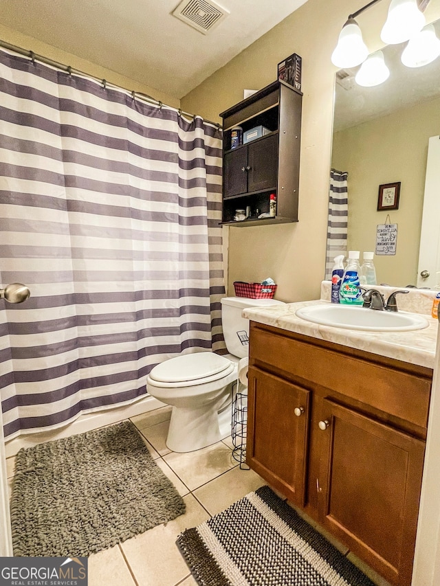 bathroom featuring walk in shower, vanity, tile patterned flooring, and toilet