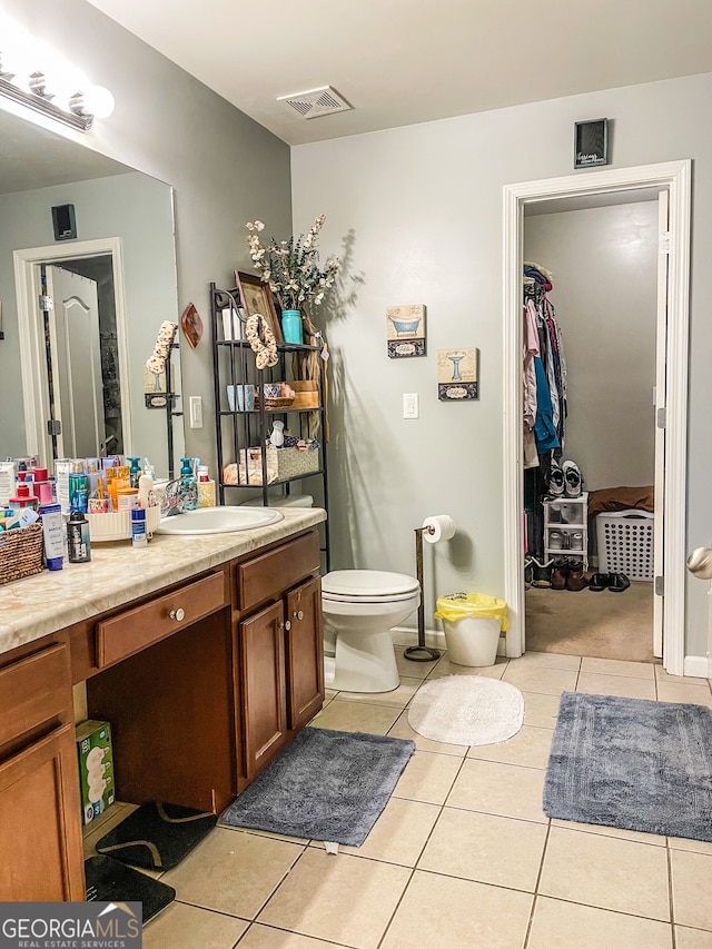 bathroom with vanity, toilet, and tile patterned floors