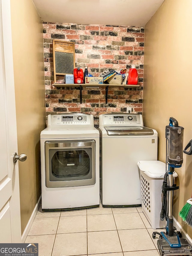 clothes washing area with washing machine and clothes dryer and light tile patterned floors