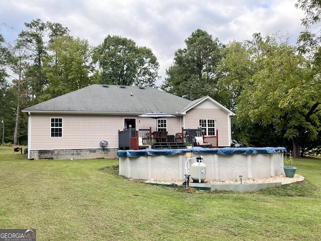 rear view of house with a lawn and a deck