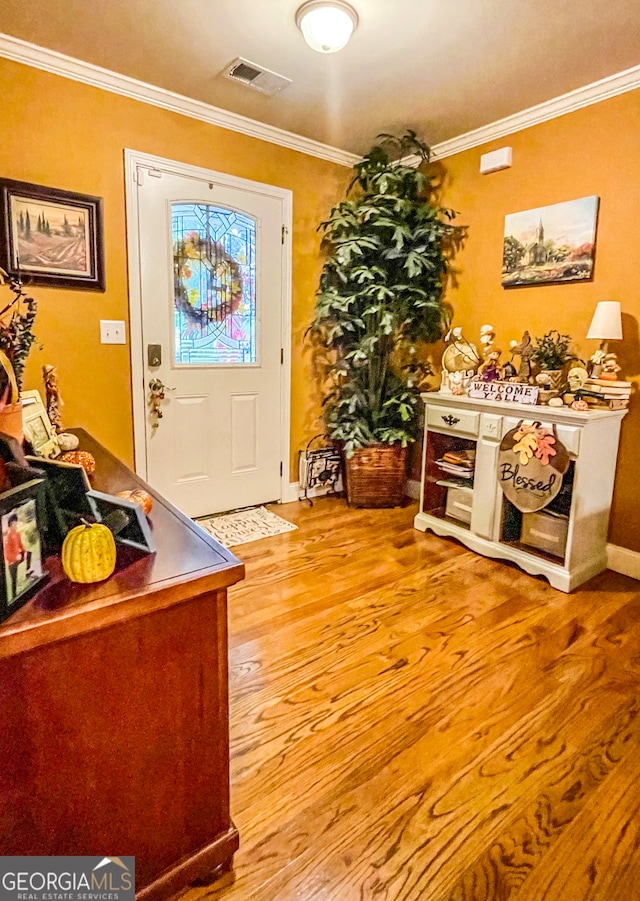 foyer entrance featuring ornamental molding and light hardwood / wood-style flooring